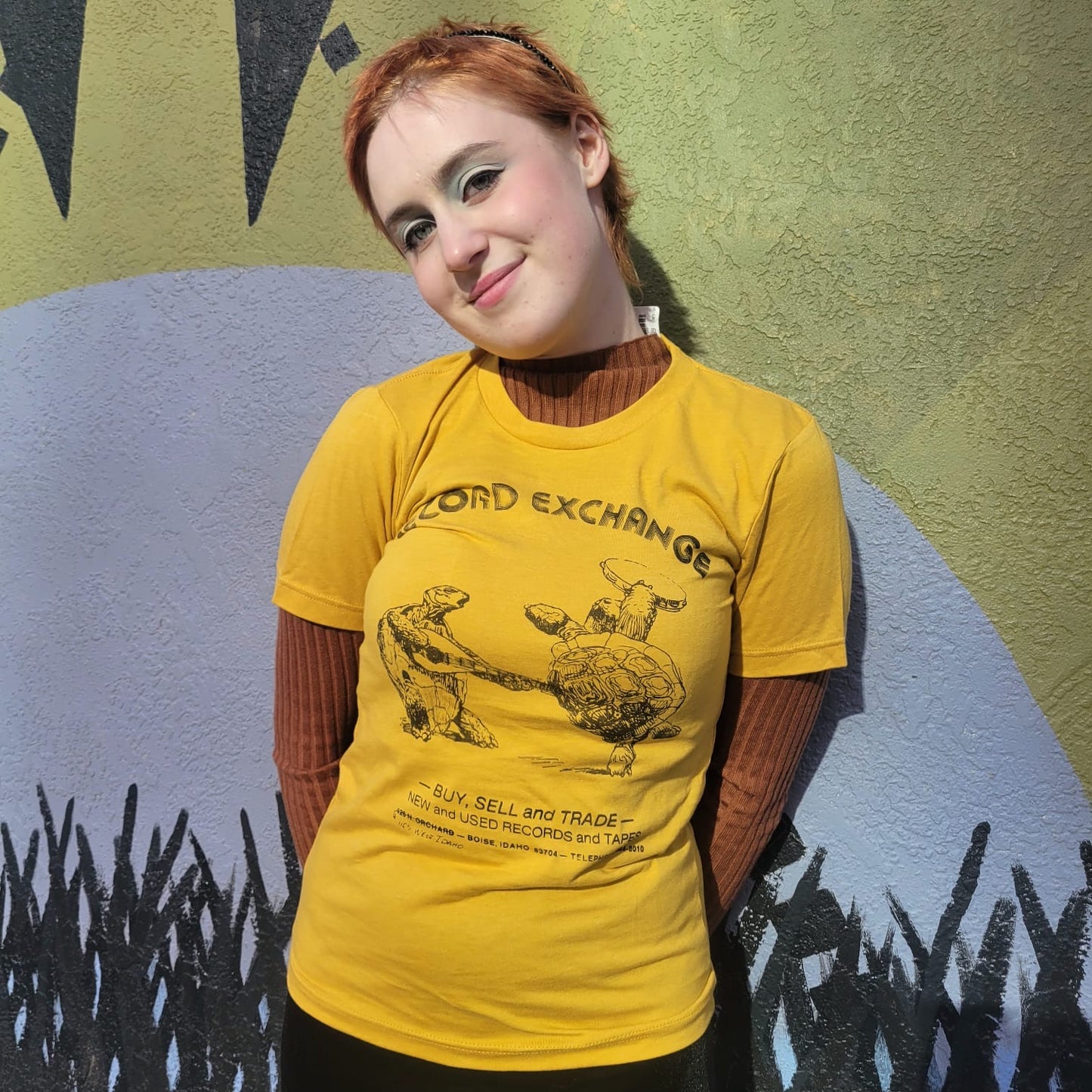 Model displaying Throwback Vintage Yellow T-Shirt with original Turtle Design by The Record Exchange Boise Idaho.
